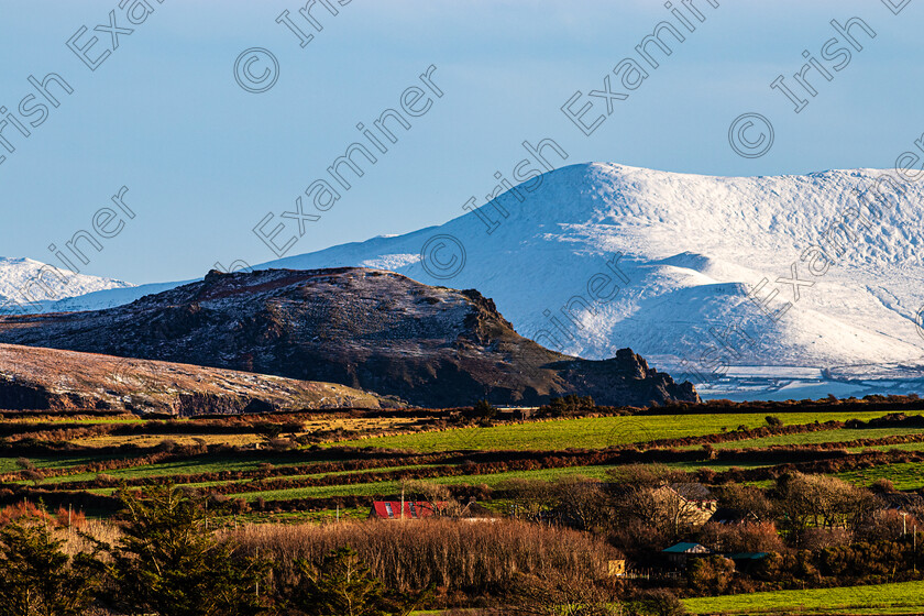 Bulls Head -Iveragh-snow-3597 
 "Bulls Head" Dingle Co Kerry in foreground with a snow covered Iveragh Peninsula in South Kerry in the distance.Taken with a telephoto lens which brings the background detail closer 
 Keywords: Dingle, snow