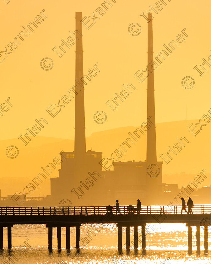 Buggys Wooden Bridge 
 Pedestrians strolling across the Wooden Bridge, Clontarf, Dublin, in the lovely low January winter light.