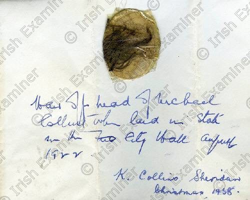 1403122 
 NO REPRO FEE : An envelope containing a lock of tangled brown hair, cellotaped to a disc, the envelope inscribed 'Hair of head of Michael Collins when laid in State in the City Hall August 1922', signed K. Collins Sheridan, Christmas 1958, and in her hand.
Kitty Collins Sheridan was Michael Collins' elder sister. She inherited many memorabilia of Collins, and distributed some of them to friends of Collins or of the family in the 1950s.